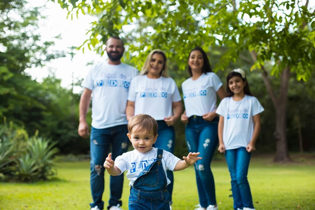 A joyful family enjoying a day outdoors with their toddler in a park, showcasing love and togetherness.